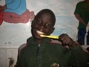 Talibe student brushing his teeth for the 1st time