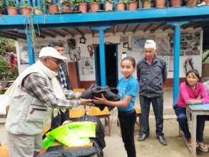 SESF Chairman  distributing jackets to the kids