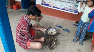 A kid cutting vegetables at the school