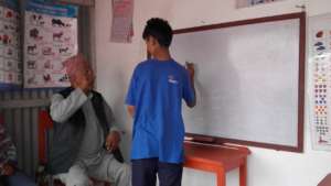 The    teachger teaching the kids to   write