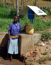 Woman next to community source chlorine dispenser
