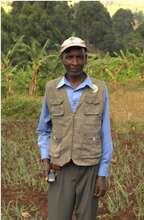 John at his farm, mobile phone in hand.