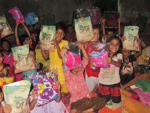 Students holding up their clothing gifts