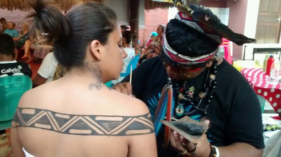 Benicio painting Ruth with indigenous art