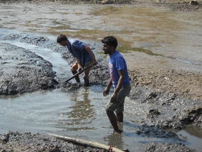 Labour Removing Slush from underneath Pond Water
