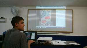 Carlos showing his facebook page at graduation