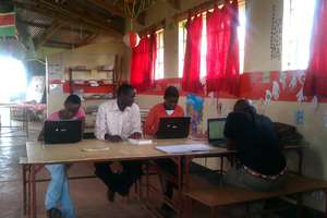 Computer Lab Teacher Issac works with his students