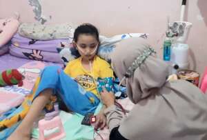 Lani gets her blood pressure checked by nurse Tyas