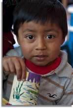 A little Story Hour learner shows off his artwork.