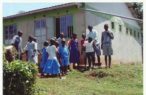 Nyakome students beneath pipes going to tank