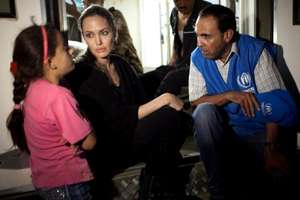 Angelina Jolie speaks with a young Syrian refugee