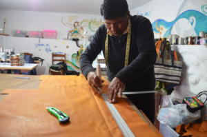 Senor Tomas cutting leather