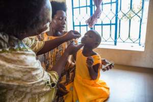 Child taking drops at clinic