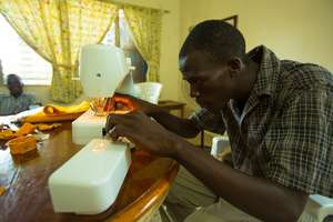 Macintosh (country director) learning how to sew!