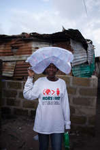 Krubo bringing water to quarantined families.