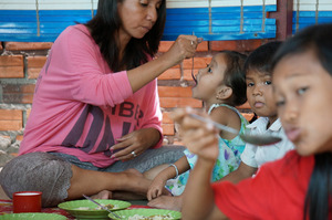 Housemother feeding Riverkids' Daycare toddlers