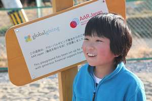 A boy from Temporary Housing Complex at signboard