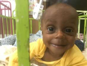 Welton smilling through the bars of his bed!