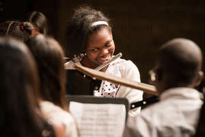 A student plays her flute enthusiastically!