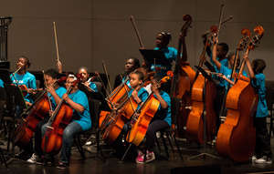 An orchestra prepares to play their song.