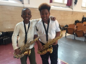 Two saxophone players smile after a concert!