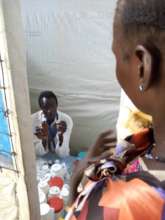 A mother receives medicine from our clinic in Doro
