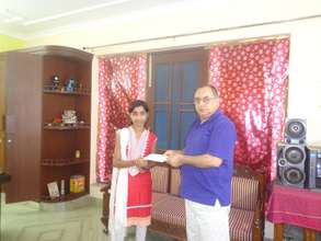 Neha receiving her scholarship for Higher Studies