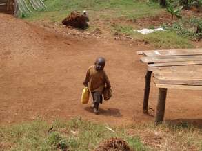 Small boy collecting water in Bushekeri