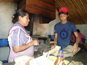 A boy learning how to make tortillas