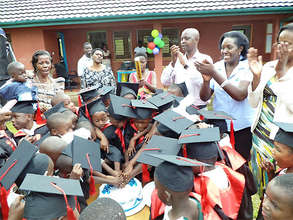 Children moving on to elementary school cut a cake