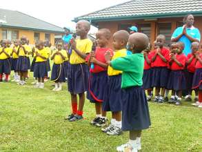 Children say a prayer to start off the sports day.
