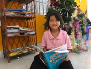 A girl reading the book at child's club