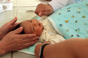 Screening newborn in rural Yunnan hospital.