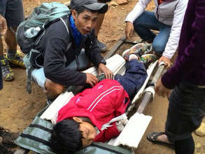 Dusun mountain guides help a young injured climber