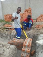 Foster instructing Nkosi on foundation building