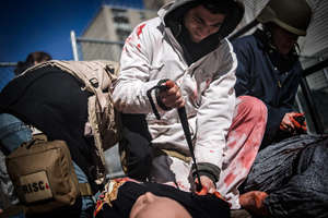 Photographer Jonathan Rashad applies a tourniquet