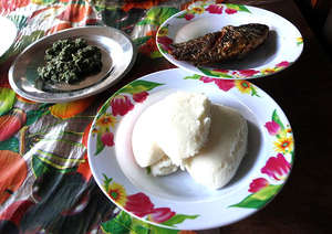 Nshima (front), fried bream and pumpkin leaves