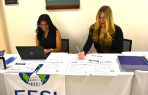 Aastha and Andie help briefing attendees check in