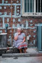 woman in front of her home (M. Shiereck/Unsplash)