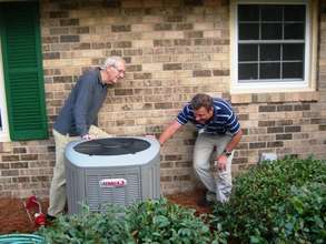 Co-op worker and homeowner inspect a new heat pump