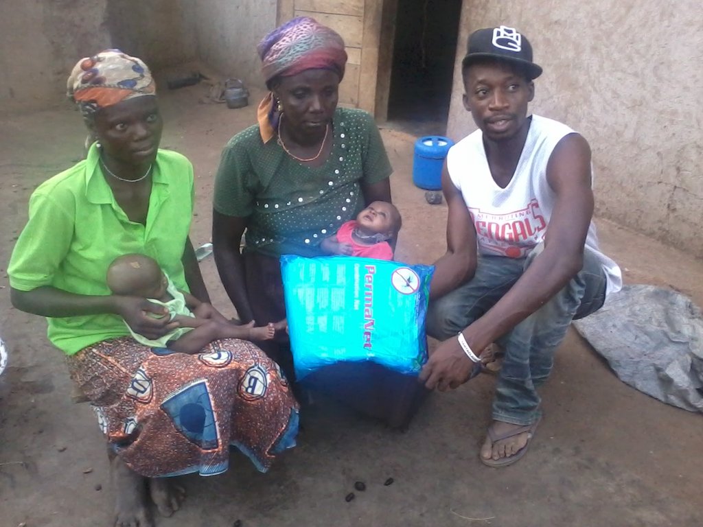 A mother with her twins receiving donated net