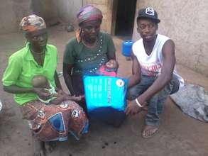 A mother with her twins receiving donated net