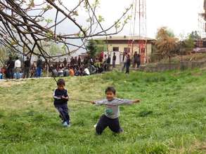 Two kids playing by the side of archery field.