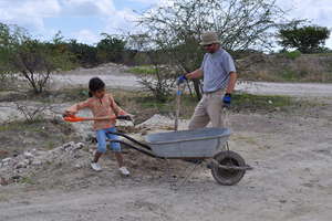 A family member shows a volunteer how it's done.