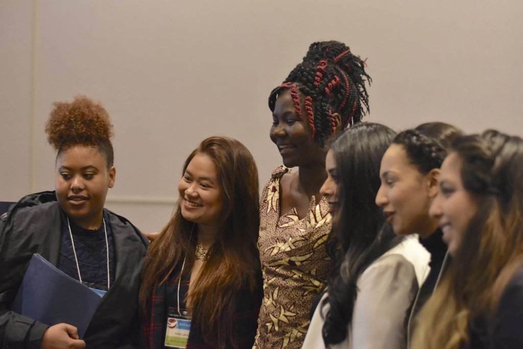 Student delegates take photos with Jane Ekayu