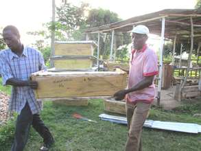 KIRUCODO Volunteers carrying finished hives 2 stor