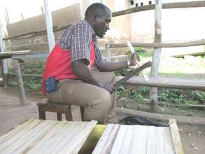 The Executive Director teaming the hive top bars