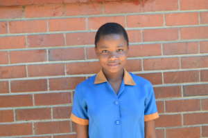 Audrey in a school uniform happy