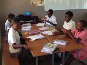 Out of school children reading in class