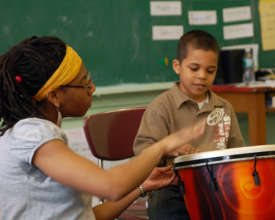A music teacher helps a student keep the beat!